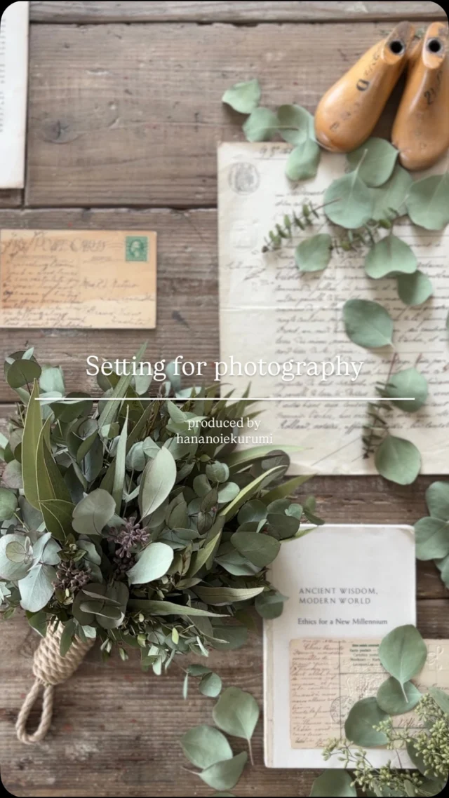 ▷撮影前のセッティング動画🎥

昨日投稿した
ユーカリロープスワッグの
作品撮影のセッティング

たっぷりたっぷり
ユーカリを束ねたスワッグは

ユーカリの葉っぱをたっぷり散らして
撮影しました

ドライ+洋書+ドライ欠片

この組み合わせが大好きで
このパターンがほとんどで

きっと
パッと見は同じように見えてると思うんですよね

色んな撮影パターンを持っている方が良いのかな？
と思うこともありますが

〝同じように見える〟

それは

〝はなのいえくるみらしさ〟

でもあるのかなと

見ただけで
あっ、これははなのいえくるみのやつだ
って分かるっていう

同じように見えるセッティングでも
葉っぱの品種、表裏、量、配置
その時その時で違っていて

その作品を引き立たせてくれるように

主役はその作品ですが
脇役が良くないと
作品も良く見えない

店舗がない分
こうした作品の写真たちは

はなのいえくるみらしさとは…を感じてもらえる
名刺代わりで店舗みたいなものと思っています

なので
オーダーをいただいた作品は
毎回必ず撮影をします

〝セッティングをして撮影をする〟

時間がかかることなんですが
私の中で
作品制作と同じくらい
大切で大事にしたいこと

店舗を持たない活動になってからは
更にその気持ちが強くなったように思います

そんなこんなで
たっぷり撮影したユーカリロープスワッグ

1つ前の投稿でご覧いただけます☺︎

・
・
・

#はなのいえくるみ
#撮影動画
#ユーカリ
#ユーカリスワッグ
